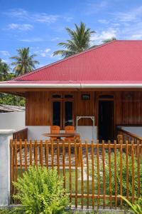 a house with a red roof and a wooden fence at Anugerah's House in Katiet