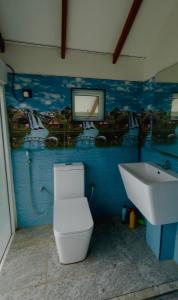 a bathroom with a toilet and a tv on the wall at LEOPARD One Villa in Gotamegama