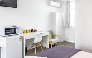 a small room with a desk and a microwave at Proserpine Motel in Proserpine