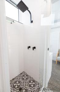 a bathroom with a shower with a black and white rug at Proserpine Motel in Proserpine