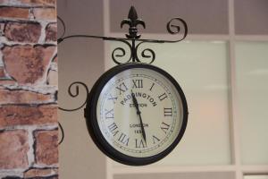 a clock mounted to the side of a wall at London Mini-hotel in Yekaterinburg