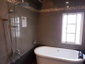 baño con bañera y ventana en ChaoPingJia Homestay, en Luodong