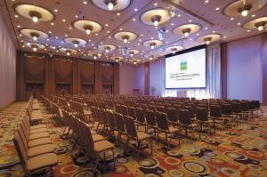 uma sala de conferências com filas de cadeiras e um ecrã em Hotel Nikko Northland Obihiro em Obihiro