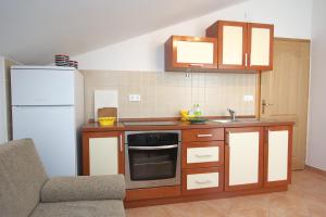 La cuisine est équipée d'un réfrigérateur blanc et d'un évier. dans l'établissement Apartments Novalja, à Novalja