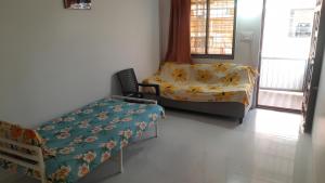 a room with a bed and a couch and a chair at Sukhada Nivas Bunglow in Trimbak