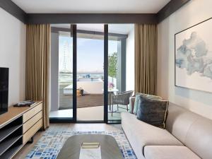a living room with a couch and a tv and a tub at Address Beach Resort in Dubai +115 photos