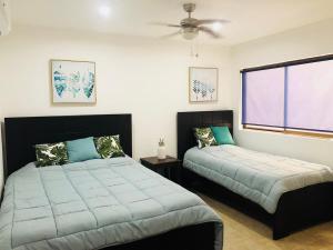 a bedroom with two beds and a window at Tama Magico in Tamarindo +40 photos