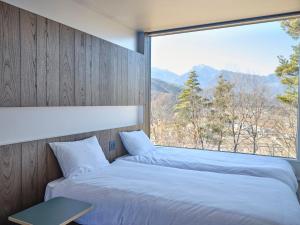 a bedroom with two beds and a large window at BLANC yatsugatake 2026年4月24日グランドオープン in Hokuto +75 photos