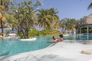 two people in a swimming pool at a resort at Six Senses Kanuhura in Lhaviyani Atoll