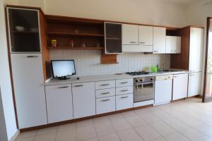 a kitchen with white cabinets and a tv in it at Casa Federica Otranto Near Beach & Center AC, WiFi & 6 Sleeps in Otranto