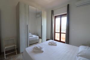 a white bedroom with a bed and a mirror at Casa Federica Otranto Near Beach & Center AC, WiFi & 6 Sleeps in Otranto