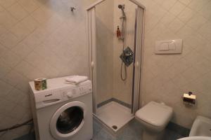 a bathroom with a washing machine and a toilet at Casa Federica Otranto Near Beach & Center AC, WiFi & 6 Sleeps in Otranto