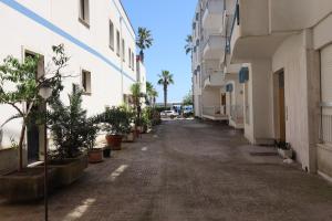 an empty alley between two buildings with palm trees at Casa Federica Otranto Near Beach & Center AC, WiFi & 6 Sleeps in Otranto