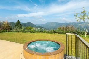 a wooden hot tub sitting on top of a field at Uga Ghiri - Ella - All Inclusive in Ella