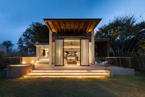 a house with a wooden roof and a patio at Uga Ghiri - Ella - All Inclusive in Ella
