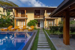 a villa with a swimming pool in front of a house at Villa Bentota B24 in Bentota
