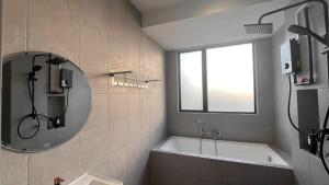 a bathroom with a bath tub and a mirror at HOMESTAY WITH 2 BEDROOMS IN NILAI for Malaysian traveler in Nilai