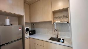 a kitchen with a sink and a refrigerator at HOMESTAY WITH 2 BEDROOMS IN NILAI for Malaysian traveler in Nilai