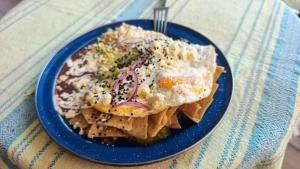 a blue plate of food with an egg and chips at Casa Laud Chacahua Isla in Guayabas