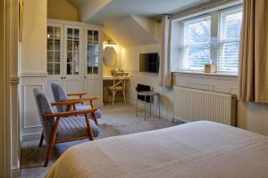 a bedroom with a bed and chairs and a desk at Weavers Guesthouse by Weavers of Haworth in Haworth