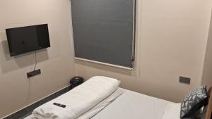 a room with a bed and a flat screen tv at Sun Hill Homestay in Siliguri
