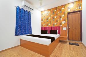 a bedroom with a bed and a blue curtain at Super Hotel O Sunshine Villa in Nagpur +40 photos