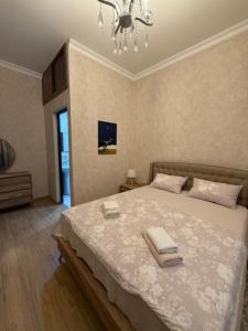 a bedroom with a large bed with two towels on it at nino hotel in Kobuleti