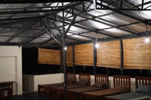 a dining room with wooden tables and chairs and lights at Unawa Retreat in Tissamaharama