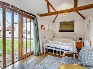 a bedroom with a bed and sliding glass doors at The Farmhouse - Uk48228 in Tibenham