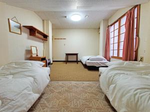 a room with three beds and a window at 横磐梯リロード in Inawashiro +43 photos