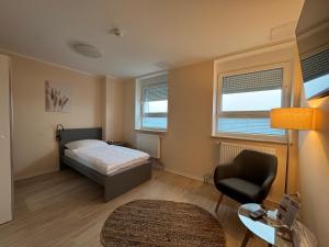 a bedroom with a bed and a chair and a desk at City Inn Schwedt in Schwedt