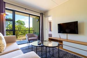 a living room with a couch and a tv at #Alimama Spaces The Future at Greenlee in Sandton