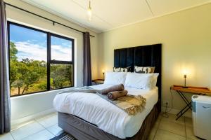 a bedroom with a large bed with a large window at #Alimama Spaces The Future at Greenlee in Sandton