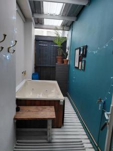 a bath tub in a bathroom with a blue wall at Haus Michau in Strand +18 photos