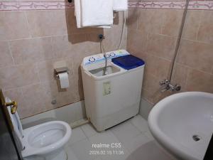 a bathroom with a white toilet and a sink at جمانا سويتس للشقق المخدومه in Al Qunfudhah