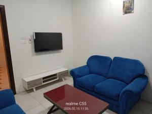 a blue couch in a living room with a tv at جمانا سويتس للشقق المخدومه in Al Qunfudhah +5 photos