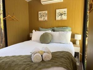 a bedroom with a large bed with towels on it at Gum Tree Hideaway by Tiny Away in Stoneville