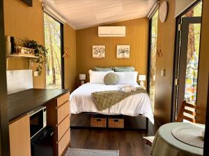 a bedroom with a bed in a tiny house at Gum Tree Hideaway by Tiny Away in Stoneville