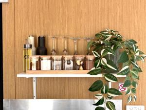 a shelf with bottles and glasses on a wooden wall at Gum Tree Hideaway by Tiny Away in Stoneville