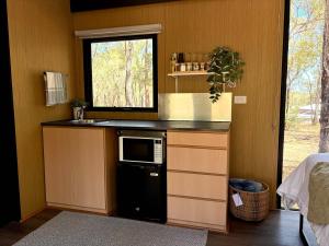 a kitchen with a sink and a microwave at Gum Tree Hideaway by Tiny Away in Stoneville +9 photos