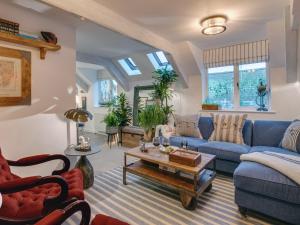a living room with a blue couch and a table at The Salt Loft in Fowey