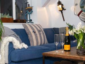 a blue couch with wine glasses on a table at The Salt Loft in Fowey