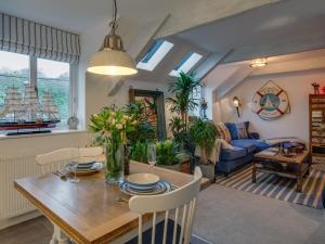 a dining room and living room with a wooden table at The Salt Loft in Fowey +9 photos