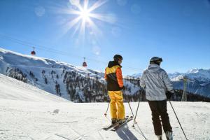 two people standing on top of a snow covered slope at Hotel Quellenhof Leukerbad in Leukerbad