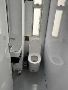 a small bathroom with a toilet and a sink at 旅居2wubin in Hong Kong