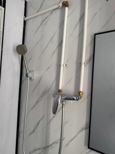 a shower head and a mirror next to a wall at 旅居2wubin in Hong Kong