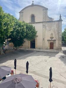 an old church with umbrellas in front of it at Chez Jo Fayence in Fayence +3 photos