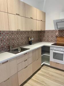 a kitchen with wooden cabinets and a sink at Chez Jo Fayence in Fayence