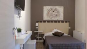 a bedroom with a bed and a desk and a sink at B&B Bruna in Florence
