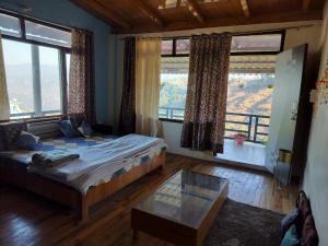 a bedroom with a bed and a large window at Nirvana Heights Kasar Devi in Hawālbāgh